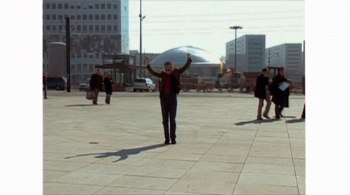 Man With Outstretched Arms In City Square GIF