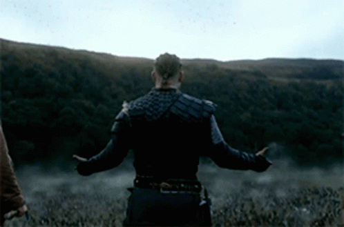 a man with his arms outstretched stands in a field