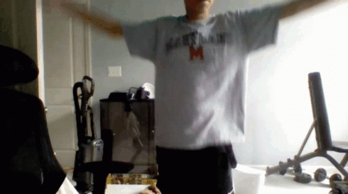 A Man With His Arms Outstretched Wearing A Maryland T-Shirt GIF