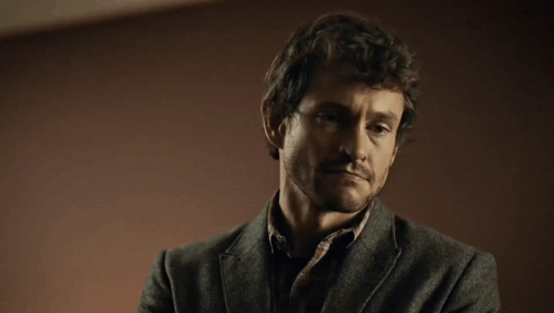 A Man With His Eyes Closed And A Beard Is Wearing A Grey Jacket GIF