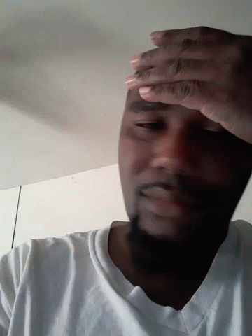 A Man With His Eyes Closed And His Hands On His Face GIF