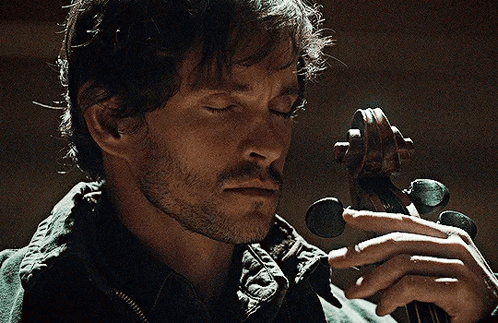 A Man With His Eyes Closed Is Holding A Violin In His Hands GIF