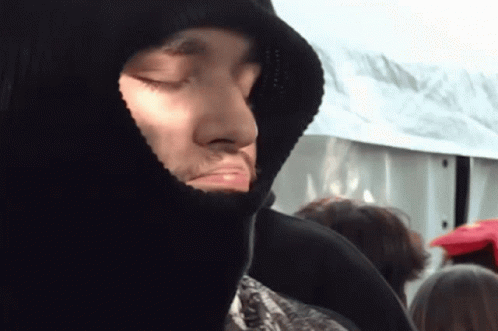 A Man With His Eyes Closed Wearing A Hooded Jacket GIF
