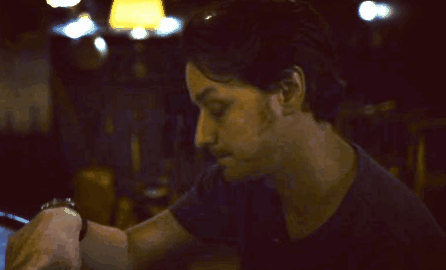 A Man With His Hand On His Forehead Looks Down GIF