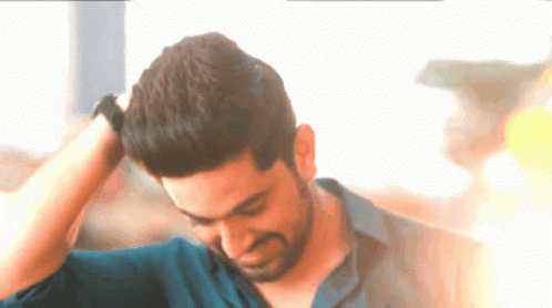 A Man With His Hand On His Head Looks Down GIF