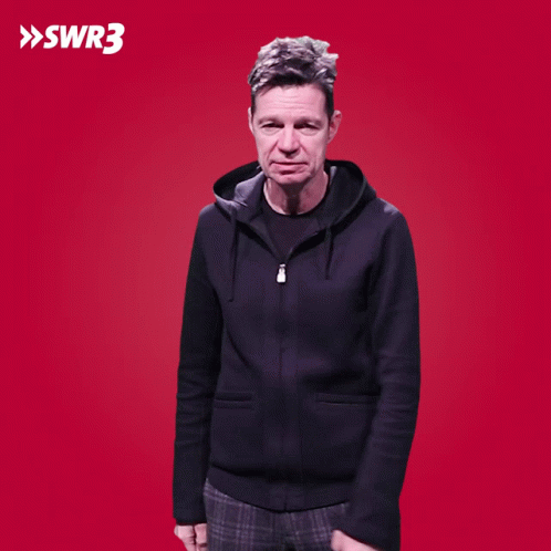 A Man With His Hands On His Hips Is Standing In Front Of A Red Background With Swr3 Written On It GIF