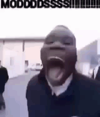 a man with his mouth open and his tongue sticking out is standing in front of a building .
