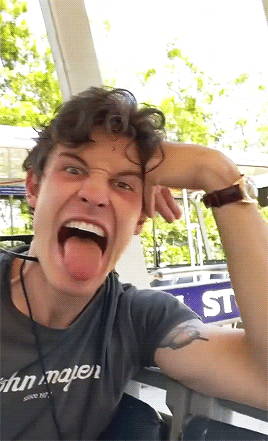 A Man With His Tongue Out Wearing A Shirt That Says John Mayer On It GIF