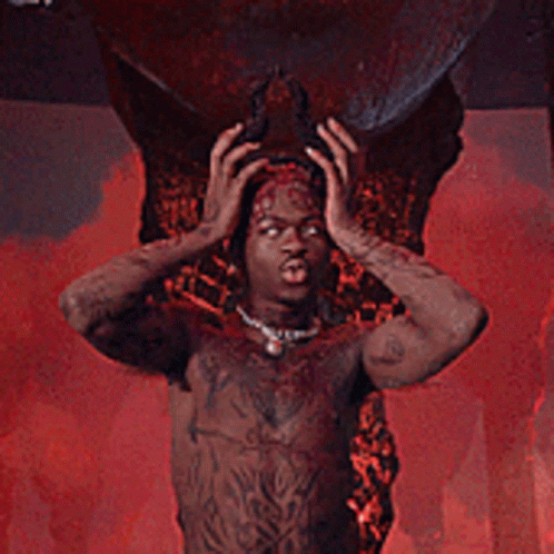 A Man With Horns And Wings Is Standing In Front Of A Large Skull GIF