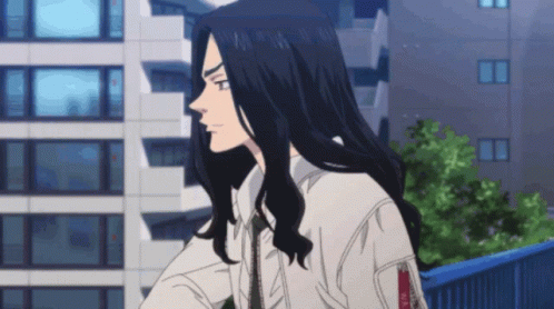 A Man With Long Black Hair Is Standing In Front Of A Building Looking Out The Window . GIF