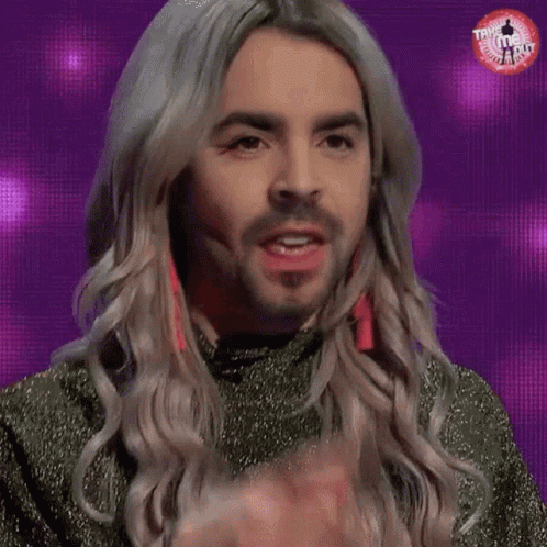 A Man With Long Blonde Hair And A Beard Is Eating A Candy Bar . GIF