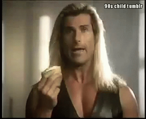 A Man With Long Blonde Hair Is Eating A Slice Of Pizza . GIF