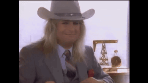 A Man With Long Blonde Hair Wearing A Cowboy Hat GIF