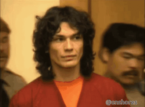 A Man With Long Curly Hair Is Standing In A Crowd Of People With The Hashtag @Snshores On The Bottom GIF