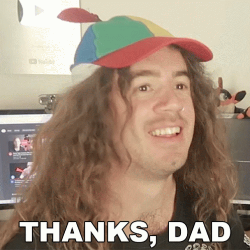 A Man With Long Curly Hair Is Wearing A Colorful Hat And Says Thanks Dad GIF