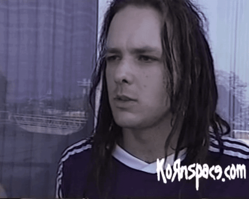A Man With Long Dreadlocks Is Wearing A Shirt That Says Kornspace.com On It GIF
