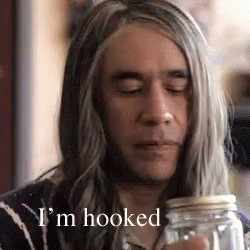 A Man With Long Gray Hair Is Holding A Jar With The Words I 'M Hooked Below Him GIF