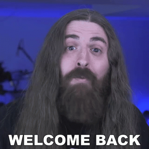 A Man With Long Hair And A Beard Has The Words Welcome Back On His Face GIF