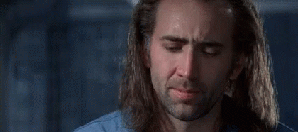 A Man With Long Hair And A Beard Is Crying In A Room . GIF