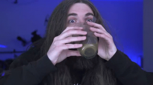 A Man With Long Hair And A Beard Is Drinking A Drink Through A Straw . GIF
