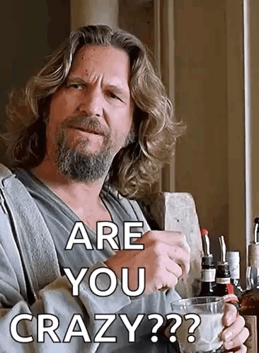 A Man With Long Hair And A Beard Is Holding A Glass Of Whiskey And Asking Are You Crazy ? GIF