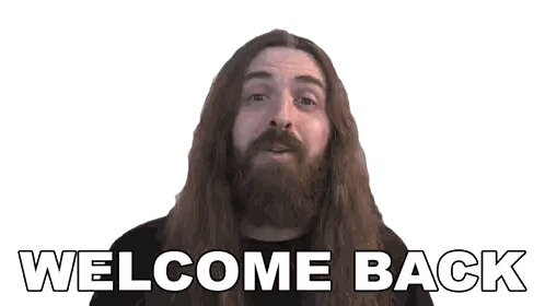 a man with long hair and a beard is holding a sign that says welcome back