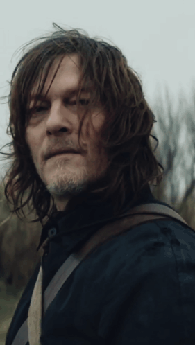 A Man With Long Hair And A Beard Is Looking At The Camera GIF