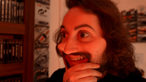 a man with long hair and a beard is making a face