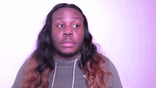 A Man With Long Hair And A Beard Is Making A Face . GIF