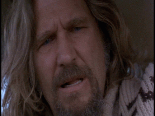 A Man With Long Hair And A Beard Is Making A Face GIF