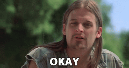A Man With Long Hair And A Beard Is Making A Funny Face And Saying Okay . GIF