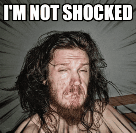 A Man With Long Hair And A Beard Is Making A Funny Face With The Words I 'M Not Shocked Above Him GIF