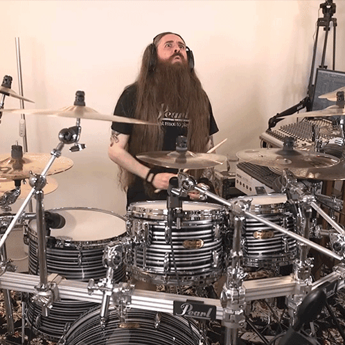 A Man With Long Hair And A Beard Is Playing Drums With A Pearl Drum Set GIF