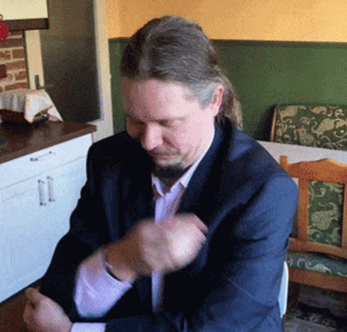 a man with long hair and a beard is sitting at a table