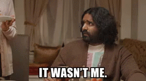 A Man With Long Hair And A Beard Is Sitting At A Table With A Laptop And A Plate Of Food . GIF