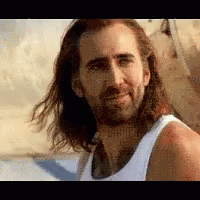 A Man With Long Hair And A Beard Is Smiling And Wearing A White Tank Top . GIF