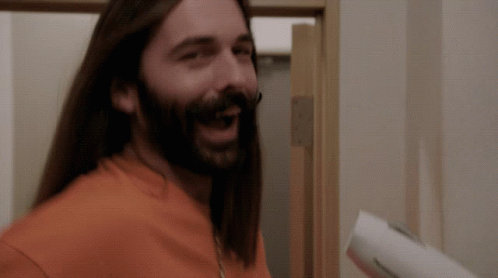 A Man With Long Hair And A Beard Is Smiling GIF