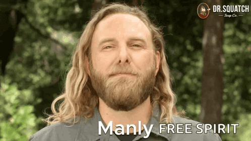 A Man With Long Hair And A Beard Is Smiling With The Words Manly Free Spirit Below Him GIF