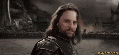 A Man With Long Hair And A Beard Is Standing In Front Of A Crowd With The Word Yolo Written On His Face . GIF