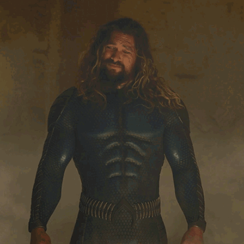 A Man With Long Hair And A Beard Is Standing In Front Of A Sign That Says " You Look Rough " GIF