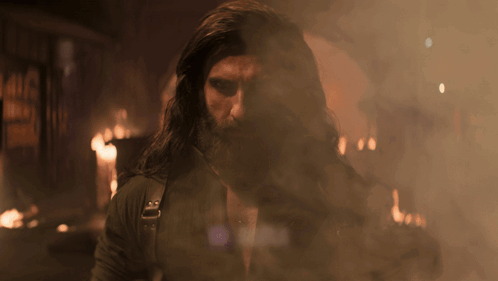 A Man With Long Hair And A Beard Is Surrounded By Smoke And Aura GIF