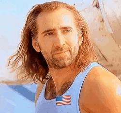 A Man With Long Hair And A Beard Is Wearing A Blue Tank Top With The American Flag On It . GIF
