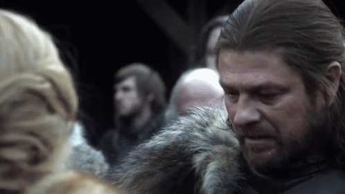 A Man With Long Hair And A Beard Is Wearing A Fur Jacket GIF