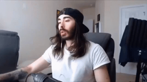 A Man With Long Hair And A Beard Is Wearing A White Shirt And A Black Hat GIF