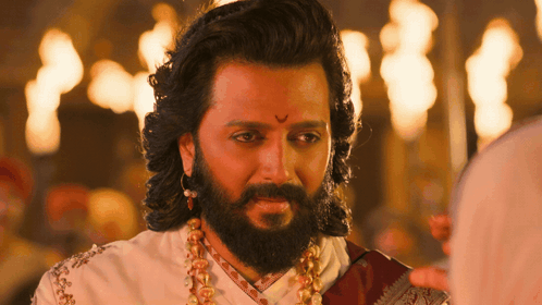 A Man With Long Hair And A Beard Is Wearing A White Shirt And A Red Scarf GIF