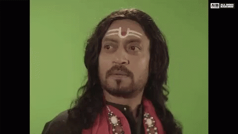 A Man With Long Hair And A Beard Is Wearing A Wig And A Headband With A Symbol On His Forehead . GIF