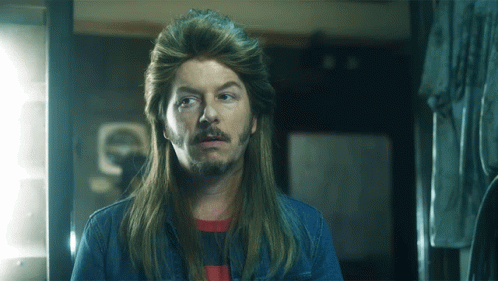 A Man With Long Hair And A Beard Is Wearing A Wig GIF