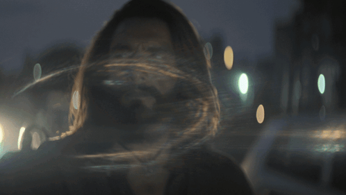 A Man With Long Hair And A Beard Looks At Something GIF