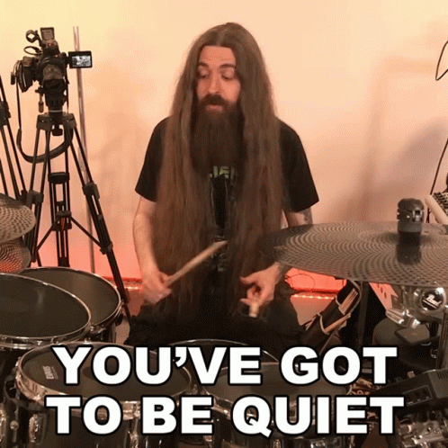 Man With Long Hair And Beard Playing Drums Saying You've Got To Be Quiet GIF