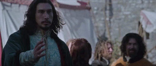 A Man With Long Hair And A Beard Stands In Front Of A Crowd GIF